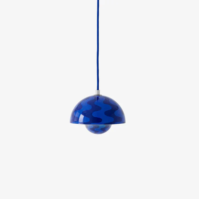 A "Stone Blue" Flowerpot VP10 pendant lamp with a blue wavy pattern hangs from a blue cord against a white background. It features a domed outer shade and a smaller, patterned inner shade.