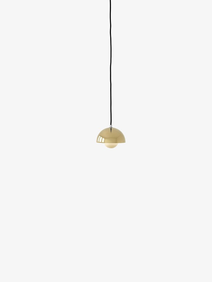 A brass-plated Flowerpot VP10 pendant lamp hangs from a black cord against a white background, featuring a domed outer shade and a smaller inner shade.