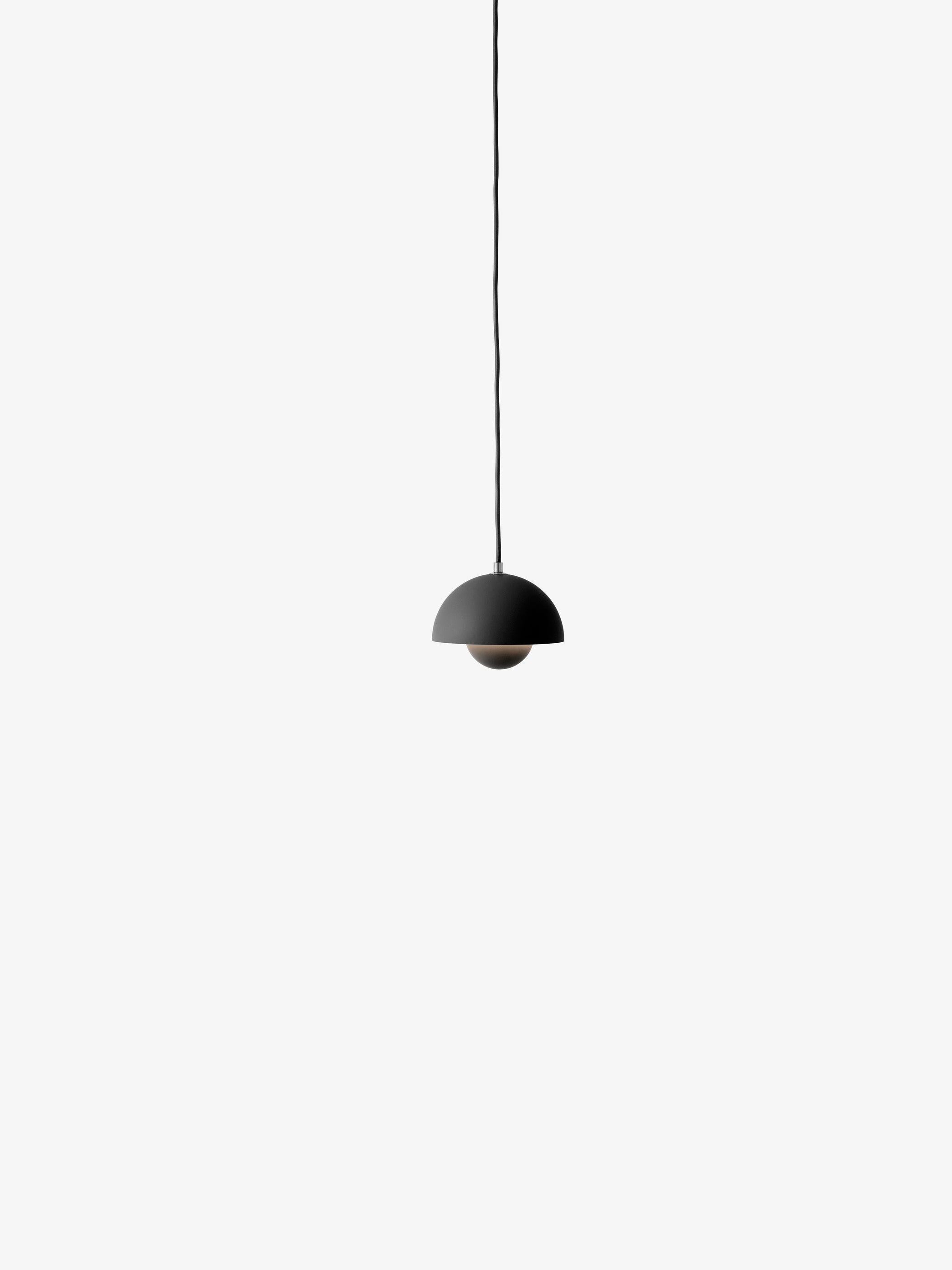 A matte black Flowerpot VP10 pendant lamp hangs from a black cord against a white background, featuring a domed outer shade and a smaller inner shade.