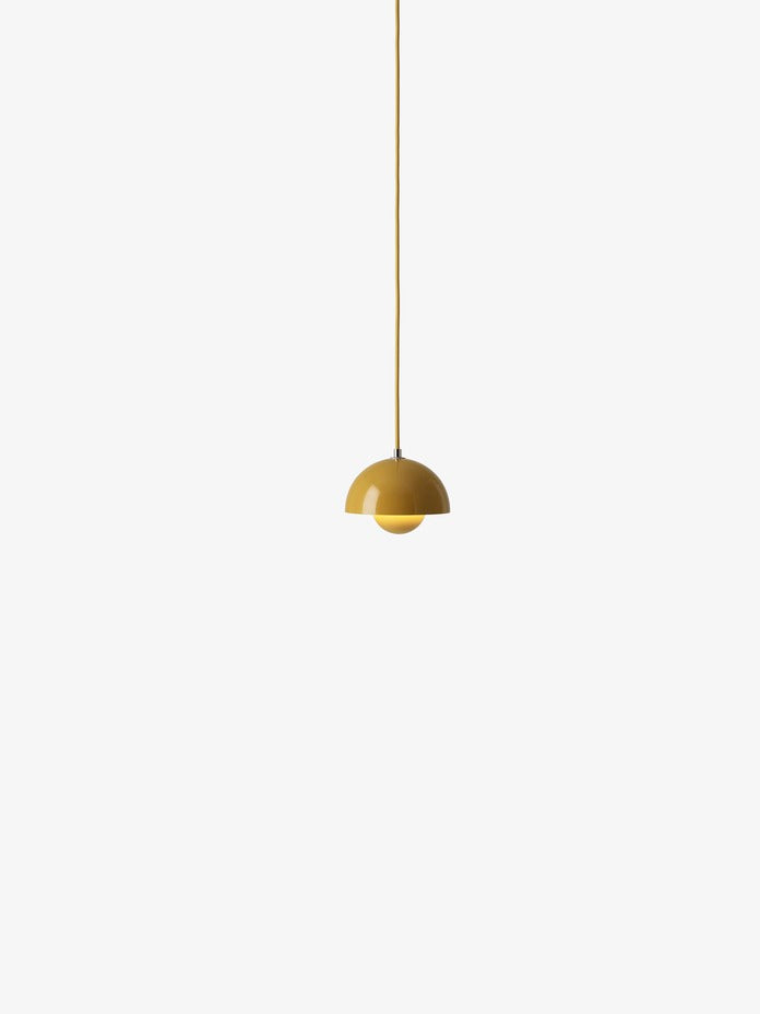 A yellow, mustard-colored, Flowerpot VP10 pendant lamp hangs from a same colored cord against a white background, featuring a domed outer shade and a smaller inner shade.